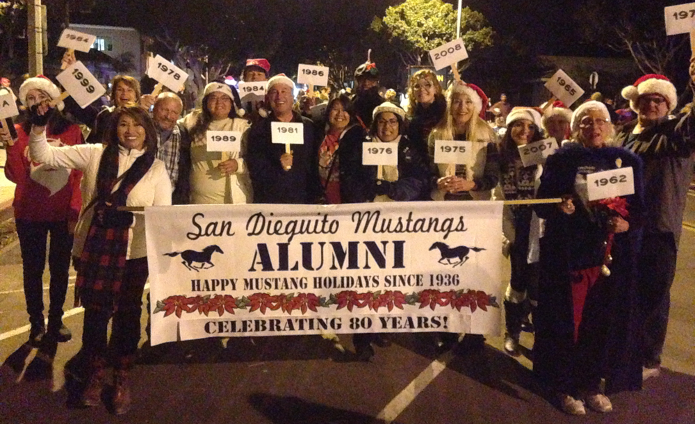 Alumni stand behind banner