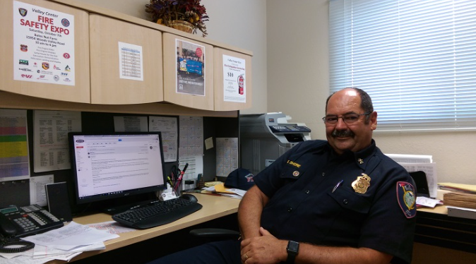 Mike in uniform, sitting at his desk