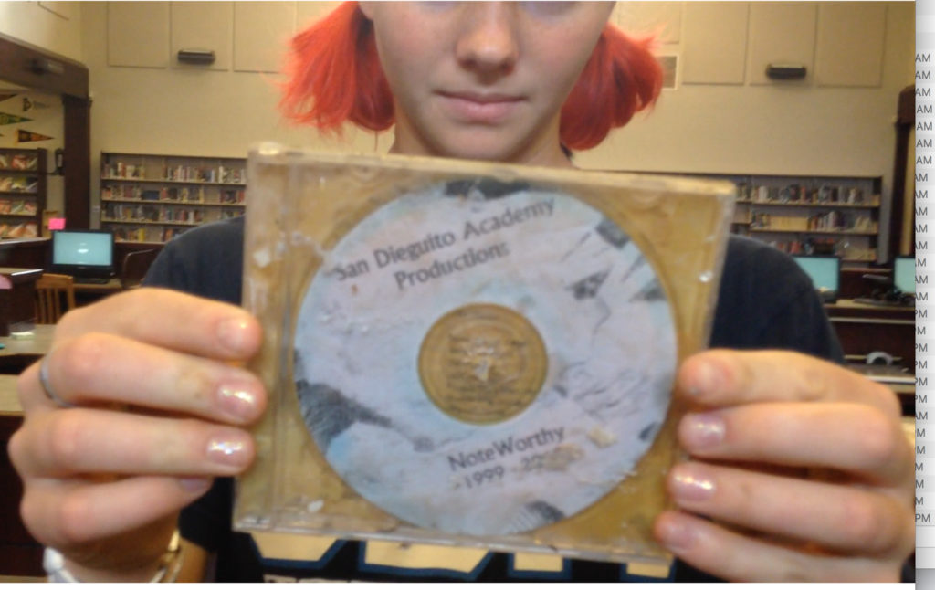 An old CD, held up by a girl
