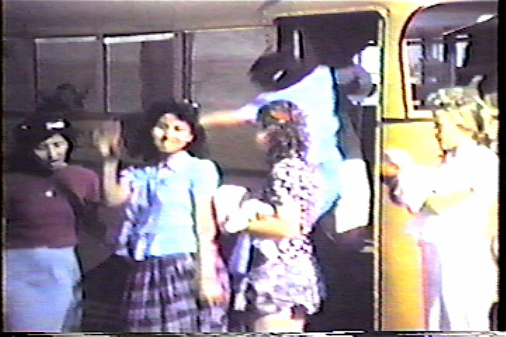 Kids filing off bus and waving
