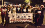 Alumni stand behind banner